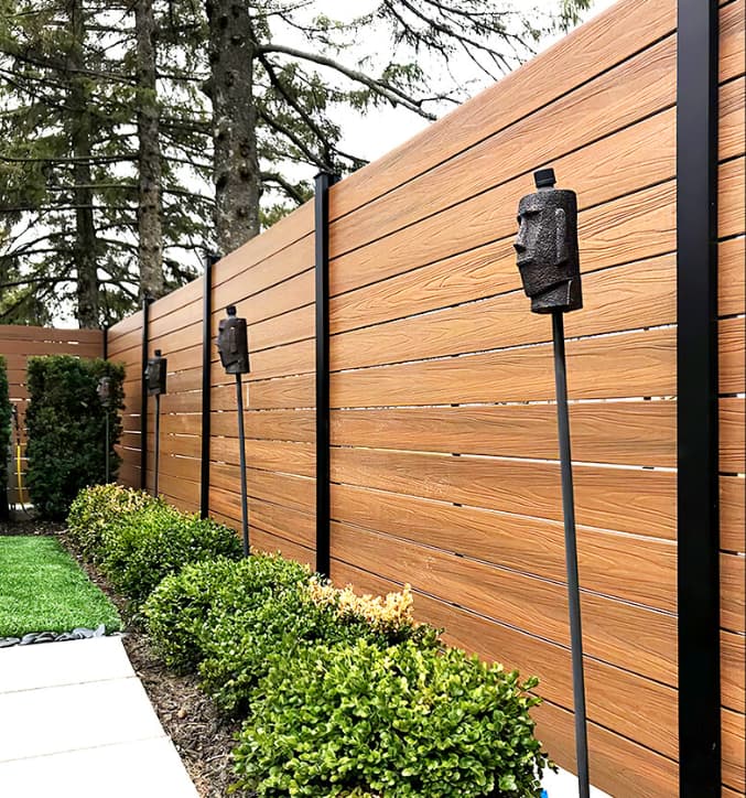 Necowood WPC fence panels installed along a residential boundary with landscaped surroundings